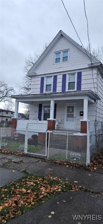 view of front of home featuring covered porch, a fenced front yard, and a gate