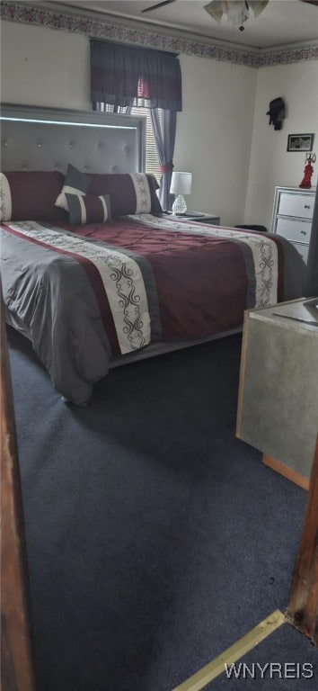 bedroom featuring ornamental molding and dark colored carpet