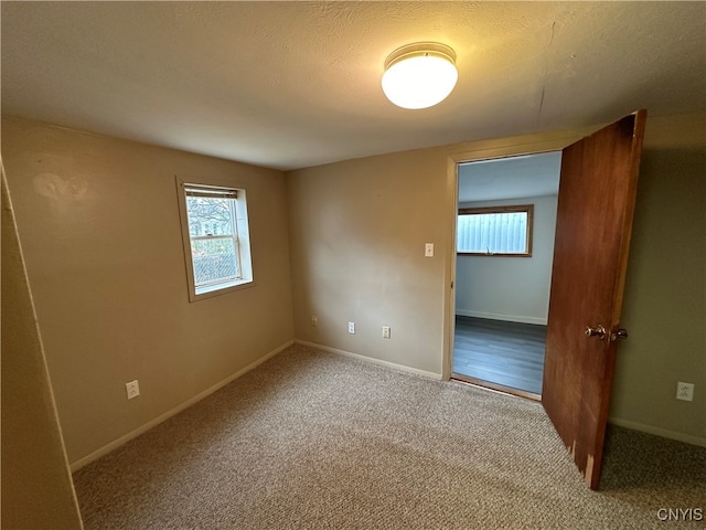 unfurnished room featuring carpet flooring and a textured ceiling