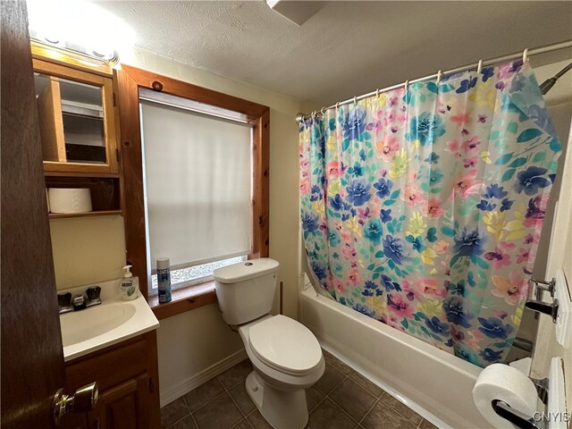 full bathroom with vanity, shower / bath combo, tile patterned flooring, toilet, and a textured ceiling