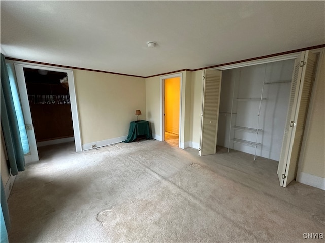 unfurnished bedroom featuring light colored carpet, a closet, and ornamental molding