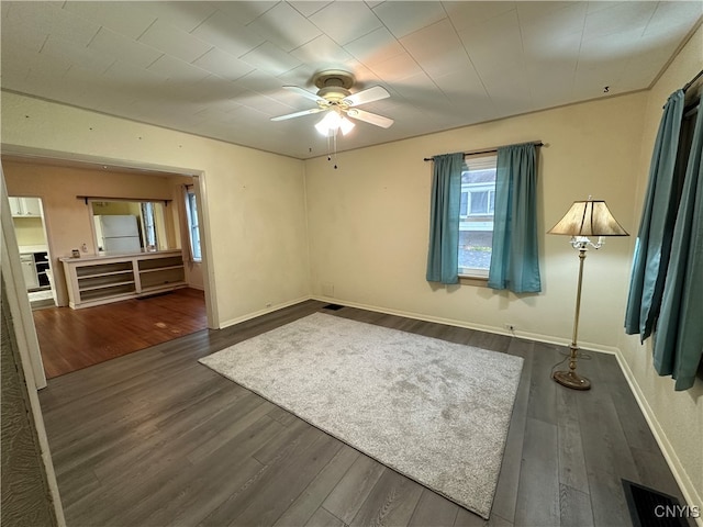 empty room featuring dark hardwood / wood-style flooring and ceiling fan