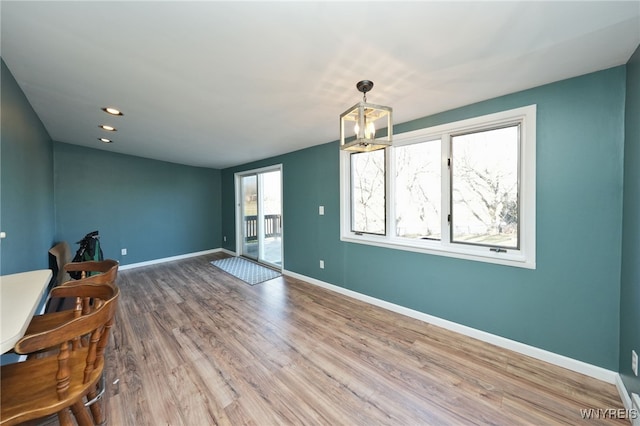 interior space featuring an inviting chandelier, a healthy amount of sunlight, and wood-type flooring