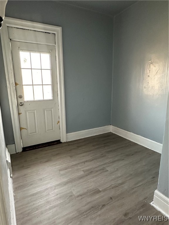 doorway featuring baseboards and wood finished floors