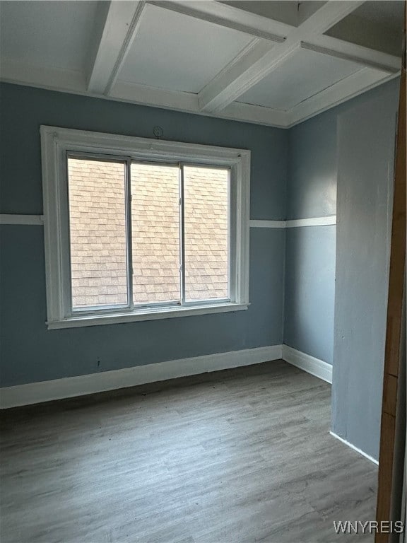 spare room featuring beam ceiling, coffered ceiling, baseboards, and wood finished floors