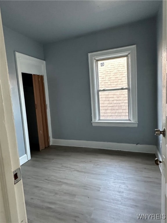 empty room featuring wood finished floors and baseboards