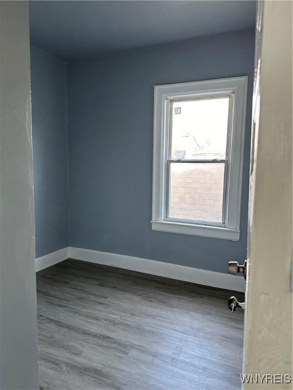 unfurnished room with baseboards and wood finished floors