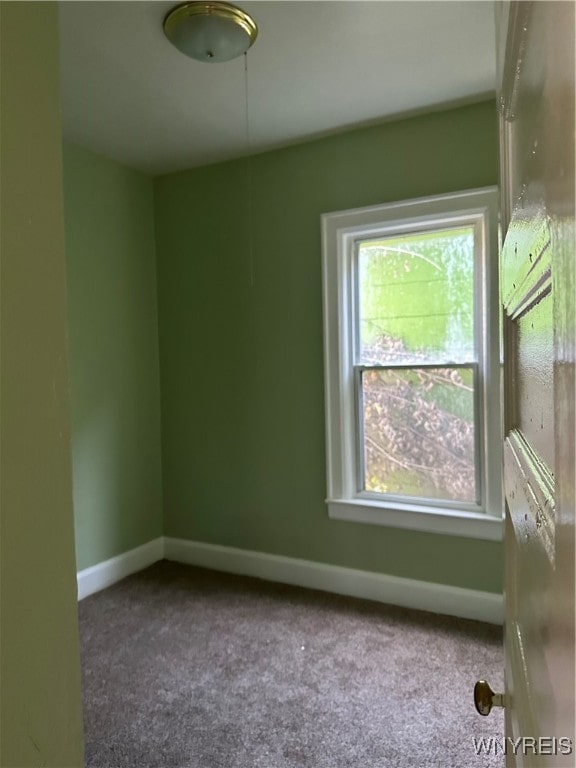 carpeted spare room with baseboards