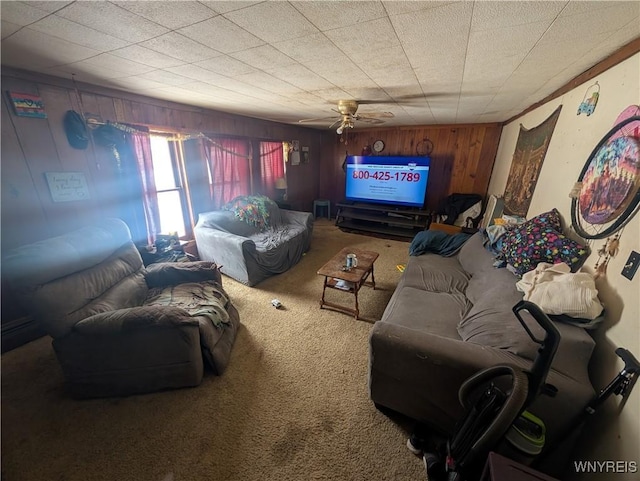 carpeted living room featuring wood walls