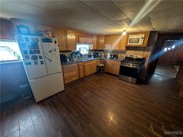 kitchen featuring dark wood-type flooring and white appliances