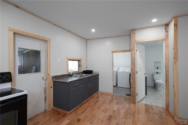 kitchen with electric range, sink, washing machine and dryer, crown molding, and light wood-type flooring