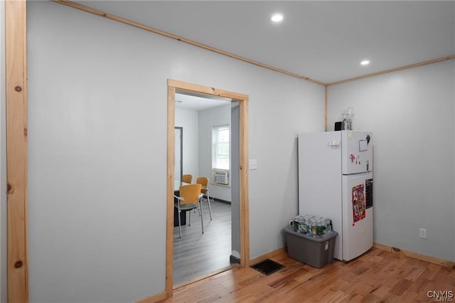 kitchen featuring hardwood / wood-style floors, white refrigerator, cooling unit, and ornamental molding