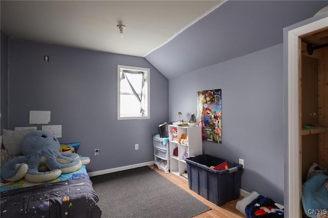 bedroom featuring hardwood / wood-style floors and vaulted ceiling