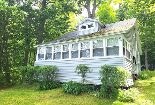 view of side of property featuring a sunroom and a yard