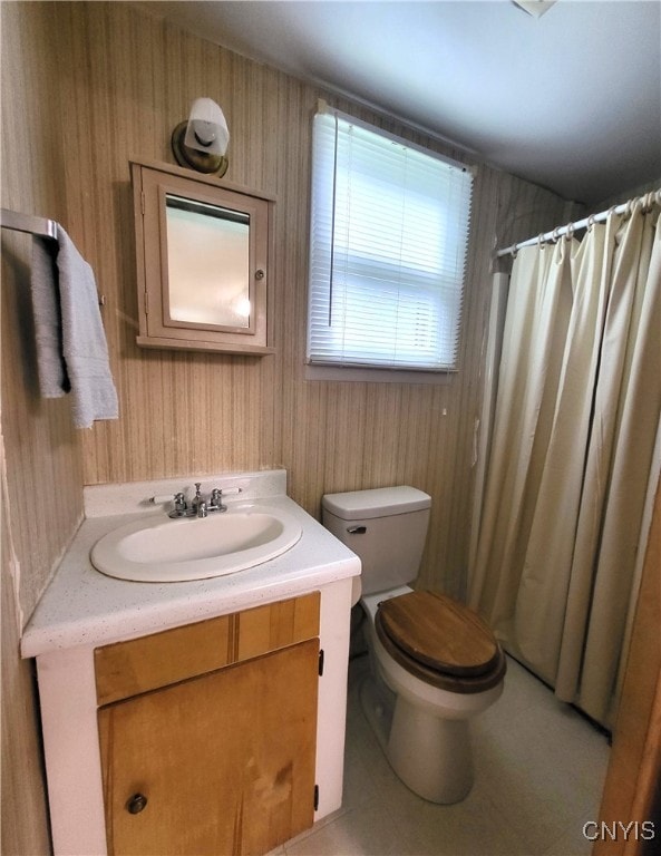 bathroom with walk in shower, vanity, and toilet