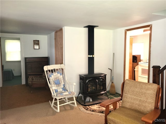 sitting room featuring carpet and a wood stove