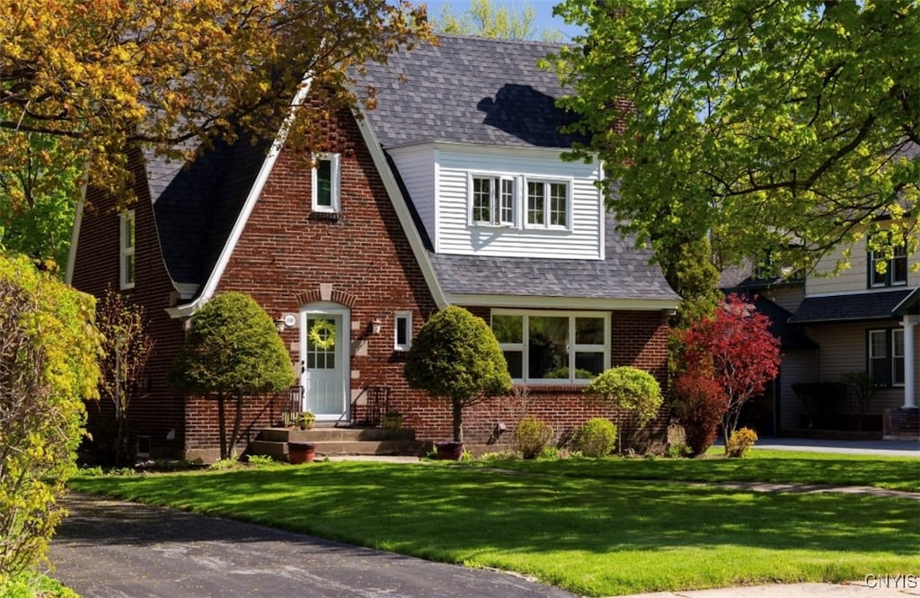 tudor-style house featuring a front yard