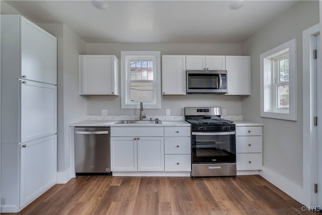 kitchen featuring white cabinets, stainless steel appliances, and a wealth of natural light