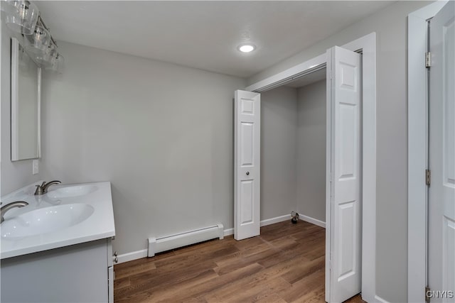 bathroom featuring hardwood / wood-style flooring, vanity, and a baseboard heating unit