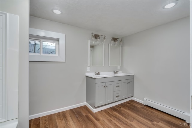 bathroom with vanity, a baseboard radiator, and hardwood / wood-style flooring