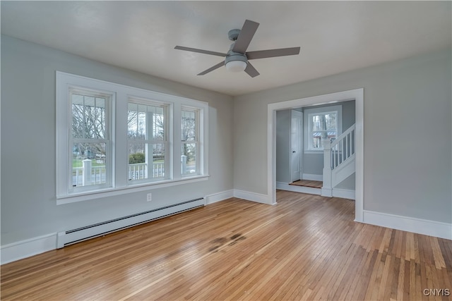 unfurnished room featuring ceiling fan, light hardwood / wood-style floors, and a baseboard heating unit