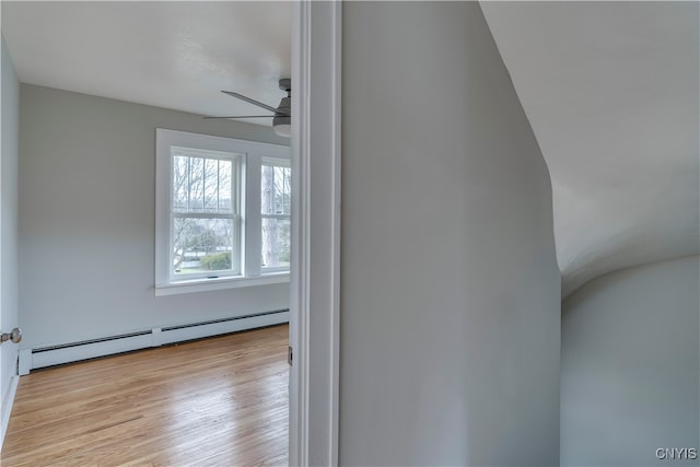 interior space featuring wood-type flooring, a baseboard radiator, and ceiling fan