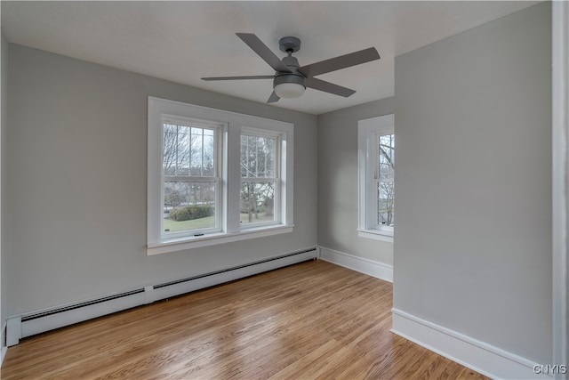 unfurnished room featuring baseboard heating, ceiling fan, light hardwood / wood-style flooring, and a healthy amount of sunlight