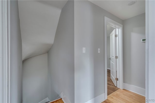 bonus room with light wood-type flooring and vaulted ceiling