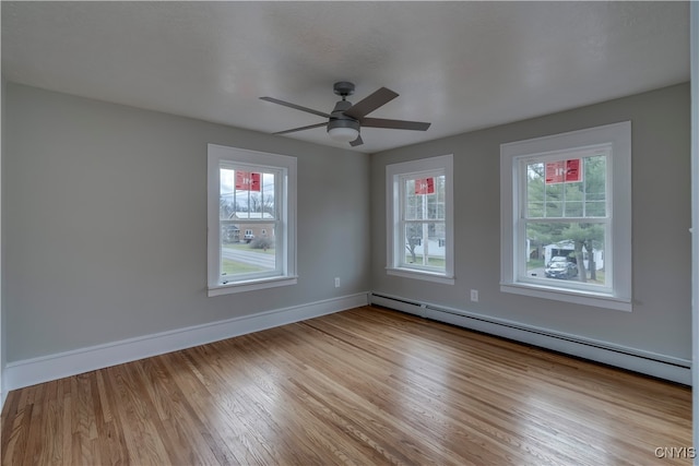 empty room with ceiling fan, light wood-type flooring, and baseboard heating