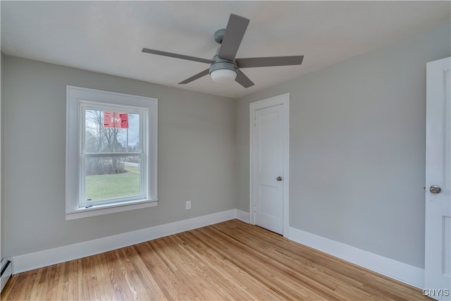 unfurnished room with light hardwood / wood-style flooring, ceiling fan, and a baseboard heating unit