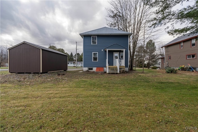 rear view of property with a yard and an outdoor structure