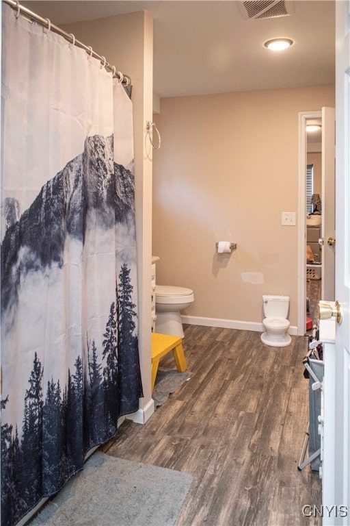 bathroom with hardwood / wood-style floors and toilet