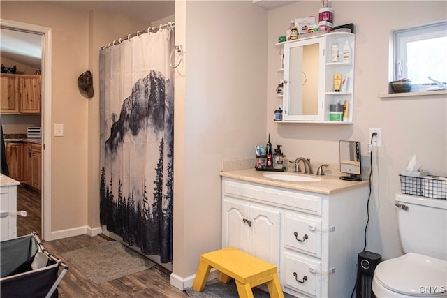 bathroom with a shower with shower curtain, hardwood / wood-style floors, vanity, and toilet