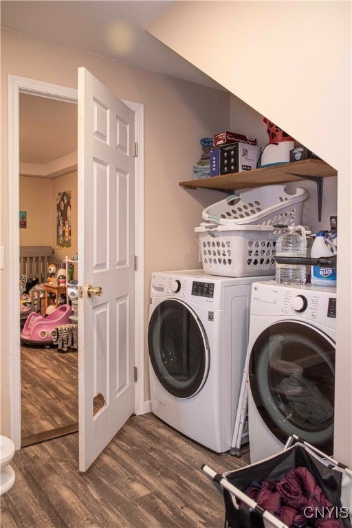 laundry room with washing machine and dryer and dark wood-type flooring