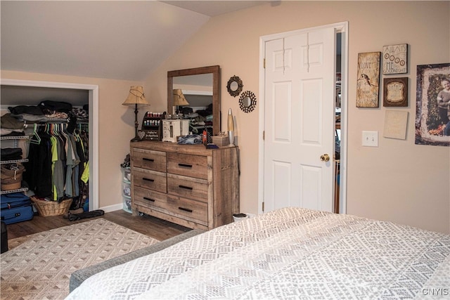 bedroom featuring hardwood / wood-style flooring, vaulted ceiling, and a closet