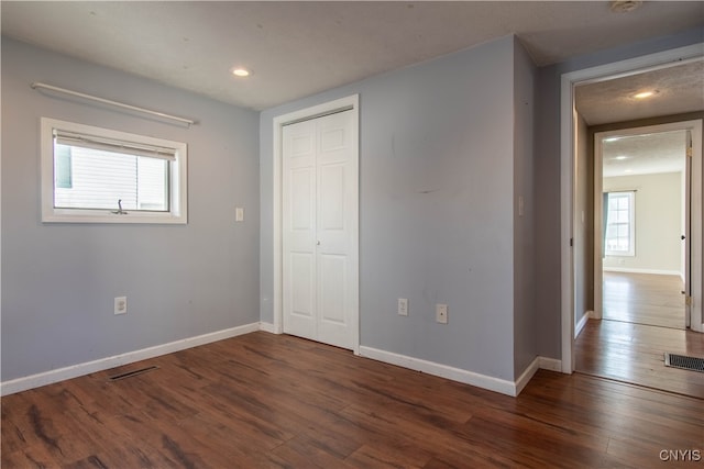 unfurnished bedroom with dark wood-type flooring and a textured ceiling