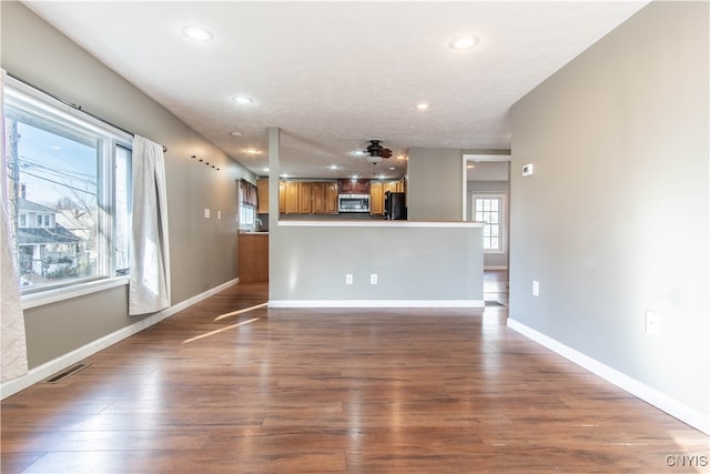 unfurnished living room with plenty of natural light and dark hardwood / wood-style floors