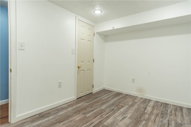 spare room with hardwood / wood-style floors and a textured ceiling