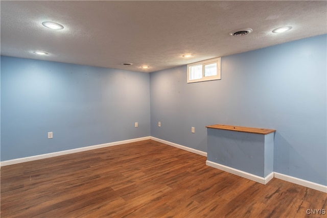 basement with hardwood / wood-style floors and a textured ceiling