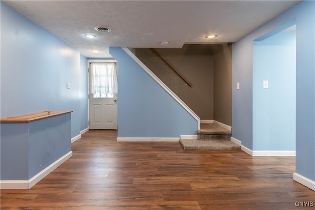 foyer entrance featuring dark hardwood / wood-style flooring and a textured ceiling