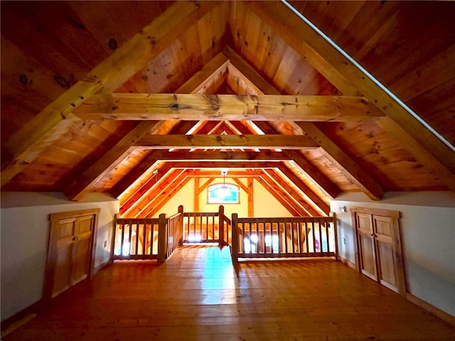 bonus room featuring vaulted ceiling with beams, hardwood / wood-style floors, and wooden ceiling