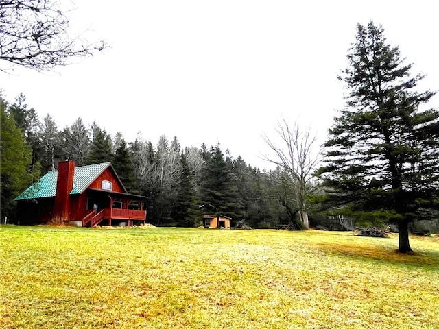 view of yard featuring a wooden deck and a storage unit