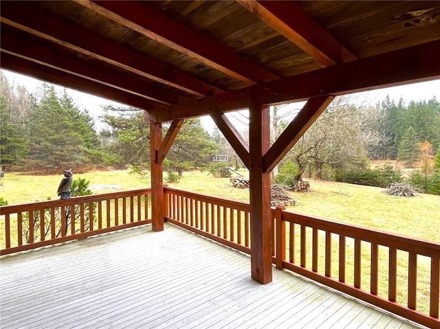 wooden terrace featuring a lawn