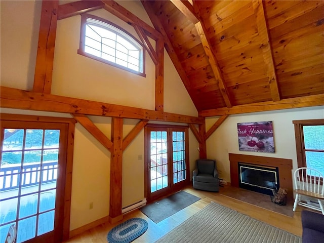 unfurnished living room with beamed ceiling, french doors, plenty of natural light, and baseboard heating