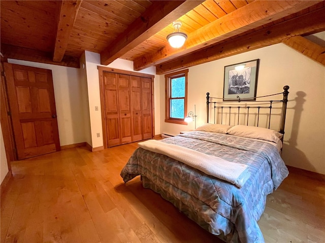 bedroom featuring beam ceiling, wooden ceiling, a baseboard radiator, light hardwood / wood-style floors, and a closet