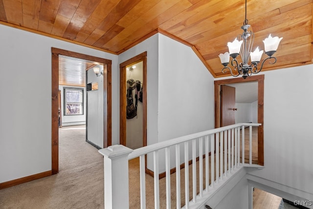 corridor with lofted ceiling, crown molding, light colored carpet, wood ceiling, and a chandelier