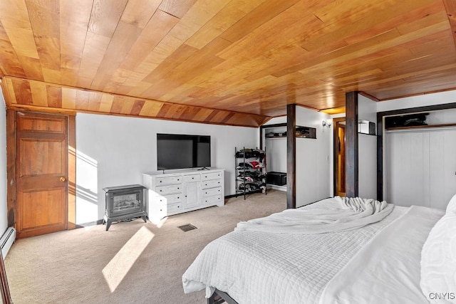 bedroom with a wood stove, vaulted ceiling, light carpet, a closet, and wood ceiling