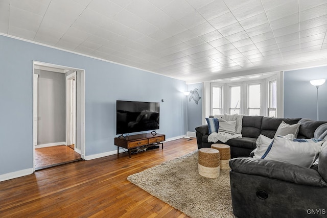 living room with crown molding and hardwood / wood-style flooring