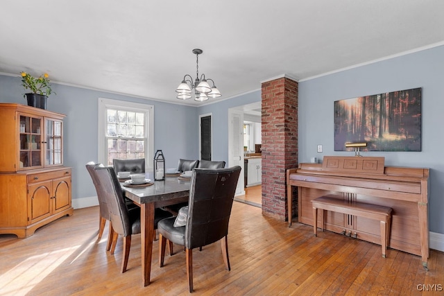 dining space featuring a chandelier, light hardwood / wood-style flooring, and ornamental molding