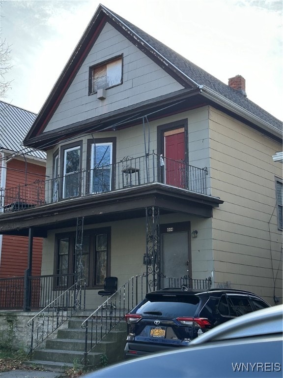 view of front of property with covered porch and a balcony